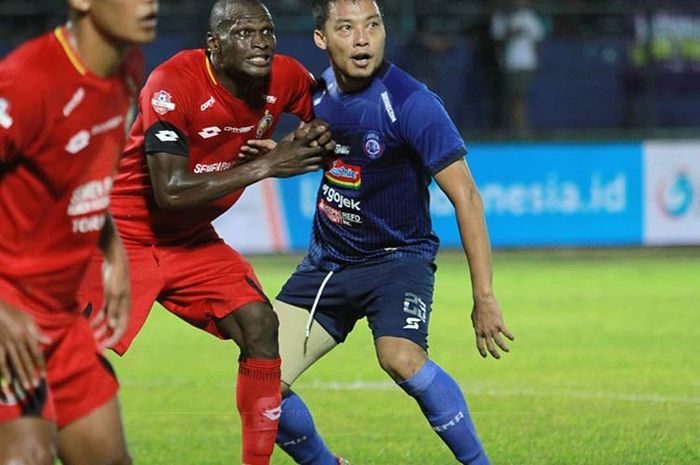 Kapten Arema FC, Hamka Hamzah, saat berduel dengan penyerang Semen Padang, Karl Max Berthelemy, pada pertandingan pekan ke-25 Liga 1 2019 di Stadion Kanjuruhan, Malang, Senin (28/10/2019).