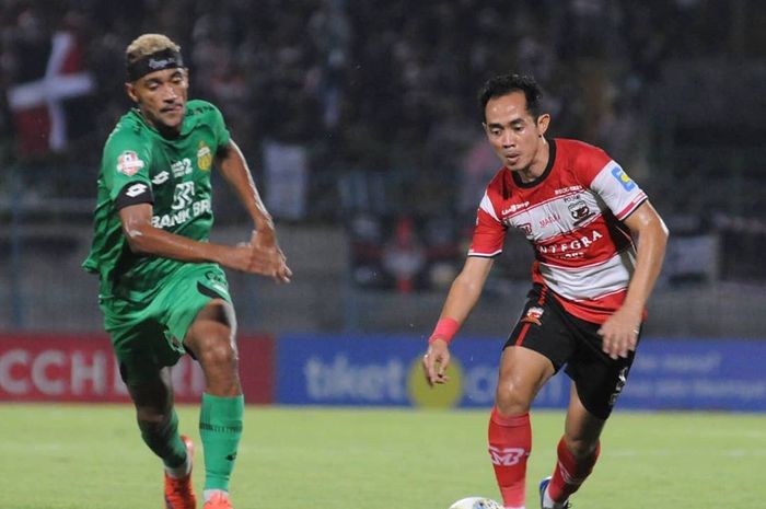 Pemain Madura United, Slamet Nurcahyo (kanan), berduel dengan pemain Bhayangkara FC, Bruno Matos, di Stadion Gelora Bangkalan, Jumat (22/11/2019).