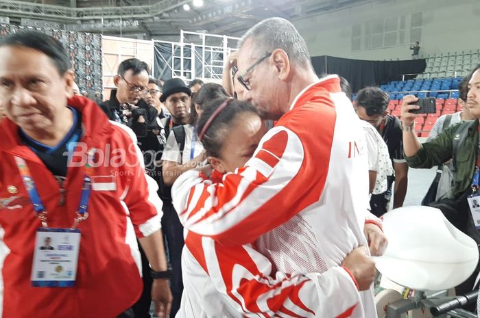 Lifter putri Indonesia, Lisa Setiawati, ditenangkan waketum PB PABBSI Djoko Pramono setelah gagal meraih medali emas di kelas 45 kg ajang SEA Games 2019 di Aquino Stadium, Filipina, Manila, Minggu (1/12/2019).