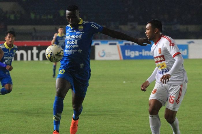 Striker Persib Bandung, Ezechiel N'Douassel (kiri), dijaga ketat pemain Perseru Badak Lampung, Saepulloh Maulana, dalam laga pekan ke-33 di Stadion Si Jalak Harupat, Bandung, Senin (16/12/2019).