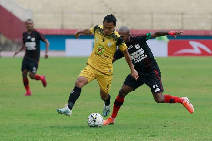 Pemain Persipura Jayapura, Boaz Solossa (kanan), berduel dengan pemain Barito Putera, Samsul Arif, dalam laga pekan ke-33 di Stadion Gelora Delta, Sidoarjo, Senin (16/12/2019).