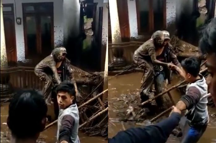 Seorang lansia dengan tubuh tertutup lumpur nampak tertatih-tatih, dibantu warga, ia berusaha lolos dari banjir.