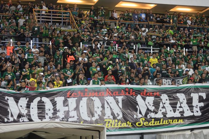 Suporter Persebaya (Bonek) membawa spanduk permintaan maaf pada warga Blitar atas kasus kerusuhan setelah laga Piala Gubernur Jatim 2020 ke laga perdana Persebaya Surabaya di Liga 1 2020 di Stadion Gelora Bung Tomo, Surabaya, Sabtu (29/2/2020).