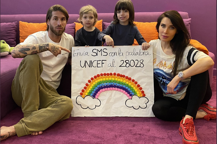 Sergio Ramos dan keluarganya berfoto bersama dengan poster yang mereka buat dengan tulisan UNICEF.