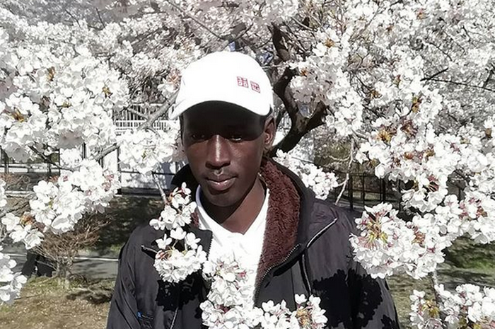 Atlet lari Sudan Selatan, Abraham Majok Matet Guem (20) berpose di depan bunga sakura.