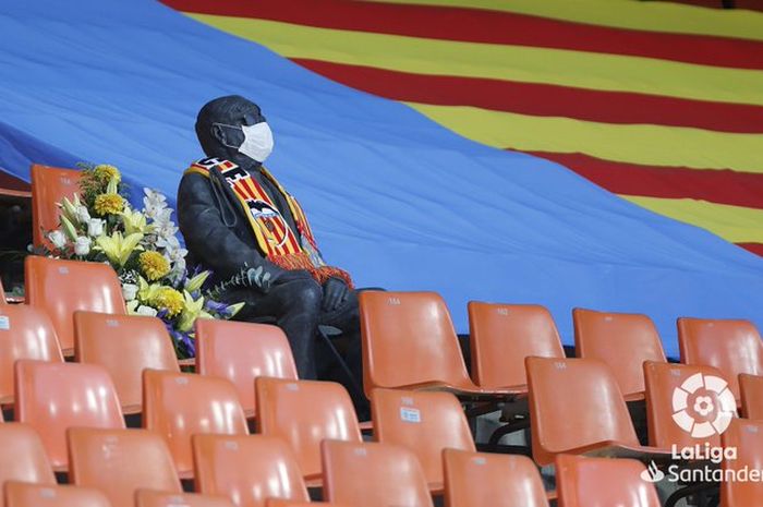 Patung suporter Valencia yang didekorasi oleh LaLiga menggunakan masker saat laga Valencia Vs Levante, Jumat (12/6/2020) atau Sabtu dini hari WIB