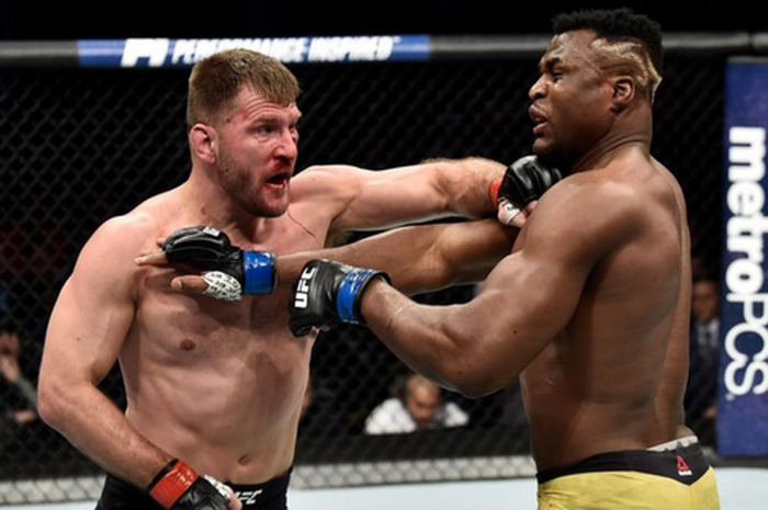 Stipe Miocic (kiri) tengah menghalau serangan Francis Ngannou (kanan) kala keduanya bertemu pada UFC 220 tahun 2018 silam.