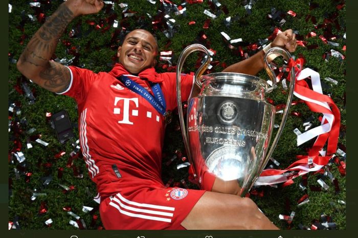 Gelandang Bayern Muenchen, Thiago Alcantara, berpose dengan trofi juara Liga Champions.