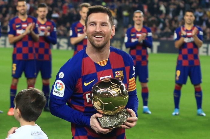 Bintang FC Barcelona, Lionel Messi, berpose dengan trofi Ballon d'Or. Messi memutuskan bertahan di Barcelona untuk musim 2020-2021.