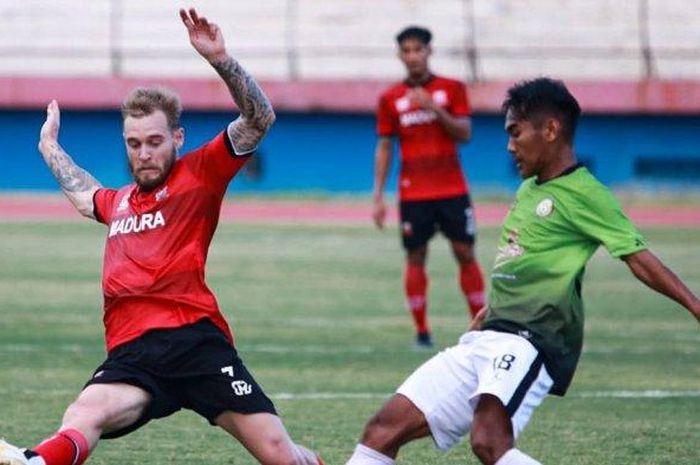 Pemain asing Madura United, Jacob Papper (kiri) berduel dengan pemain Sinar Harapan, Sidoarjo (klub Liga 3) dalam laga uji coba di Stadion Gelora Delta, Sidoarjo, Jumat (18/9/2020). 