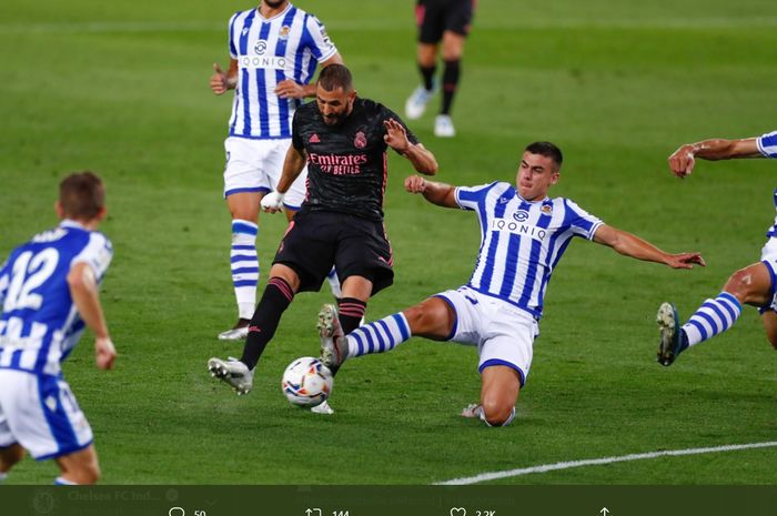 Penyerang Real Madrid, Karim Benzema, diaang satu pemain Real Sociedad kala hendak melepaskan tembakan ke gawang lawan pada laga Liga Spanyol, Minggu (21/9/2020).