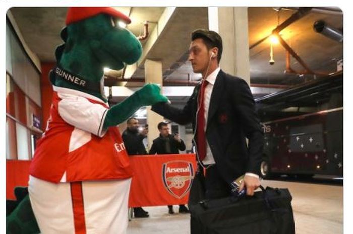 Mesut Oezil saat bersama dengan maskot klub Arsenal, Gunnersaurus.