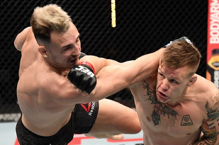 Si Brutal, Jimmy Crute (kanan) tengah menghempaskan Modestas Bukauskas dengan pukulan kanannya pada UFC Fight Island 6 (18/10/2020).