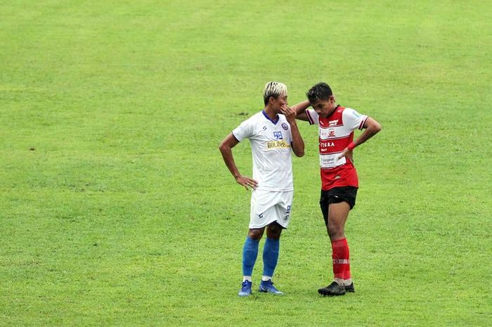 Pemain Arema FC Kushedya Hari Yudo berdiskusi dengan pemain Madura United Asep Berlian seusai game saat latihan bersama yang berakhir dengan skor 4-3 di Stadion Kanjuruhan Kabupaten Malang, Jawa Timur, Rabu (21/10/2020) sore WIB.