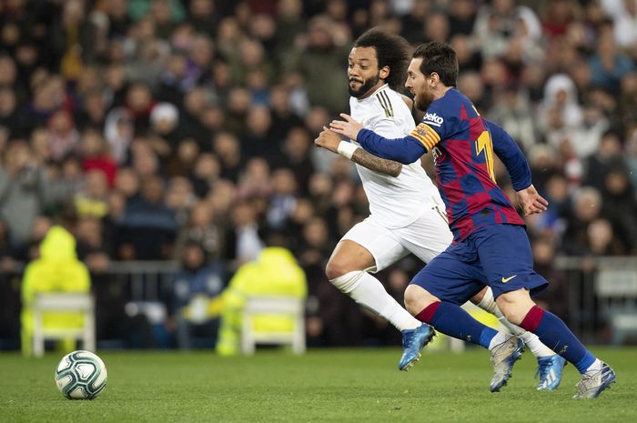 Lionel Messi berebut bola dengan Marcelo dalam momen el clasico antara Barcelona dengan Real Madrid musim 2019-2020.