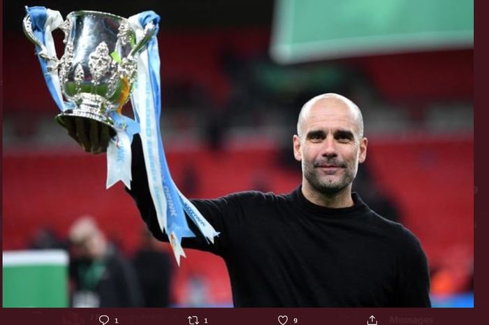 Pep Guardiola mengangkat trofi Piala Liga Inggris untuk Manchester City.