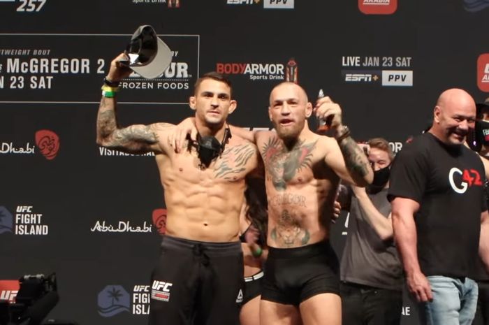 Conor McGregor dan Dustin Poirier berpelukan usai menjalani sesi timbang pada Jumat (22/1/2021)