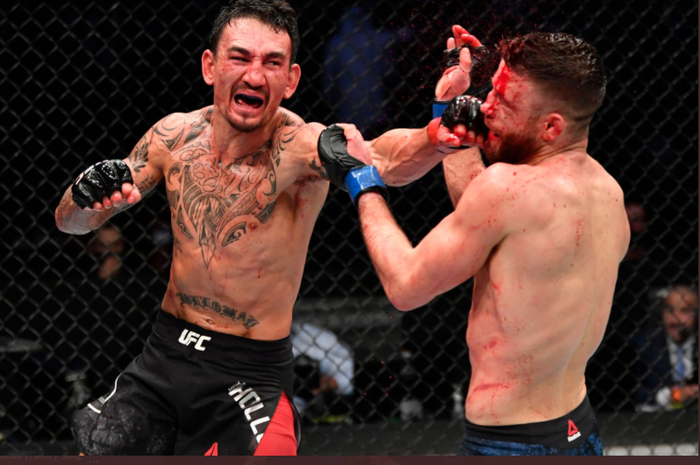 Ketika Max Holloway (kiri) sukses mendaratkan pukulan tepat ke wajah Calvin Kattar pada ajang UFC Figth Island 7 di Etihad Arena, Abu Dhabi, Sabtu (16/1/2021).