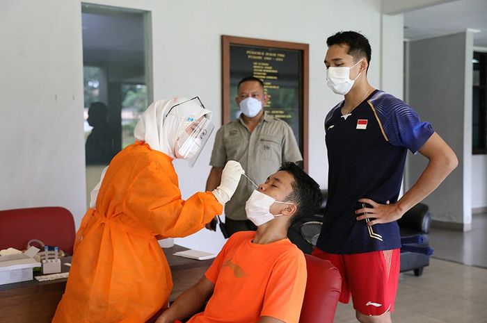 Anthony Sinisuka Ginting (duduk) dan Jonathan Cristhie (berdiri) saat menjalani tes usap antigen di Pelatnas Cipayung, Jakarta Timur, Kamis (25/2/2021).