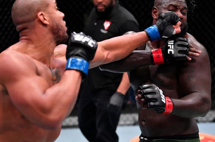 Cyril Gane (kiri) melayangkan pukulan ke arah Jairzinho Rozenstruik (kanan) saat bertarung pada acara utama UFC Vegas 20 di Las Vegas, Amerika Serikat, Minggu (28/2/2021)