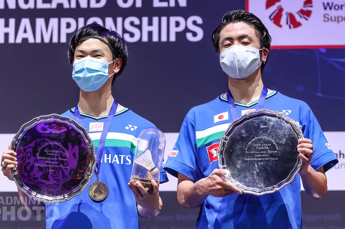 Pasangan ganda putra Jepang, Hiroyuki Endo/Yuta Watanabe, berpose dengan plakat juara All England Open 2021 usai mengalahkan rekan senegara mereka, Takeshi Kamura/Keigo Sonoda, pada laga final di Arena Birmingham, Birmingham, Inggris, Minggu (21/3/2021).