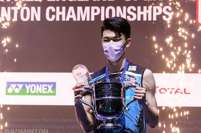 Pebulu tangkis tunggal putra Malaysia, Lee Zii Jia, memegang trofi juara pada All England Open 2021 di Utilita Arena Birmingham, Inggris, Minggu (21/3/2021).