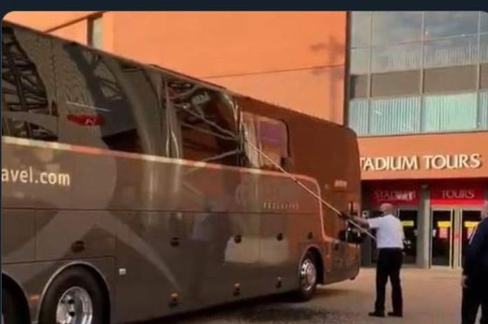 Petugas membersihkan pecahan kaca bus yang mengangkut skuad Real Madrid yang diserang oknum suporter sebelum memasuki kandang Liverpool, Anfield.