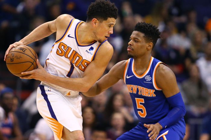 Guard Phoenix Suns, Devin Booker, dihadang guard New York Knicks,  Dennis Smith Jr.