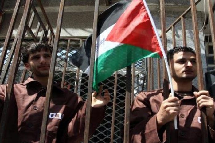 Ilustrasi bendera Palestina yang dikibarkan oleh seorang pendemo.