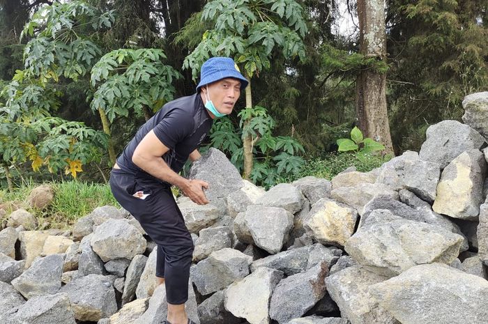 Mantan pemain timnas Indonesia dan Persib Bandung, Peri Sandria, sedang bertugas menjadi kuli batu