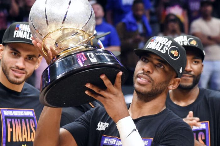 Pebasket bintang Phoenix Suns, Chris Paul, mengangkat trofi juara Wilayah Barat setelah timnya mengalahkan Los Angeles Clippers, 4-2, pada final wilayah tersebut pada playoffs NBA 2021.