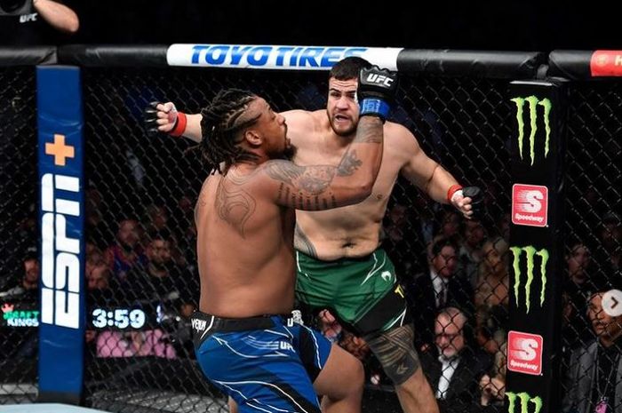 Tai Tuivasa (celana hijau), jagoan yang pernah berlatih di sasana AKA yang merupakan markas besar Khabib Nurmagomedov, memukul KO lawannya, Greg Hardy (biru) pada UFC 264 (11/7/2021).