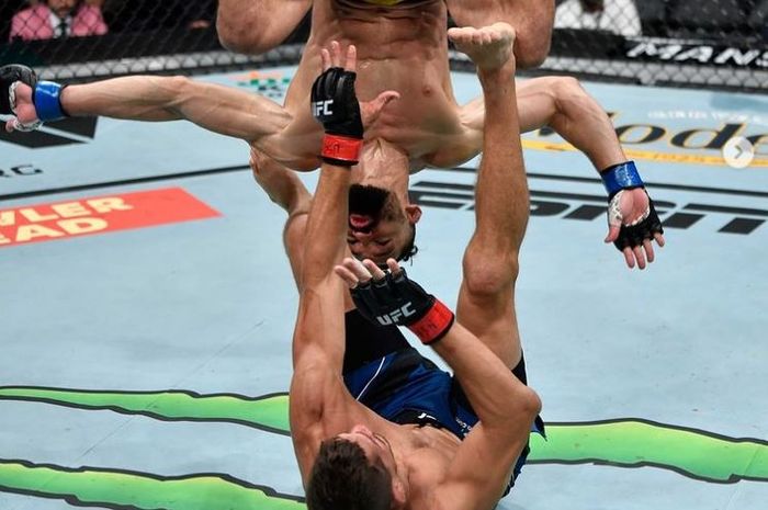 Aksi jagoan kreatif, Michel Pereira (atas) melakukan salto ke arah tubuh Niko Price (bawah) pada UFC 264, Minggu (11/7/2021) waktu Indonesia.