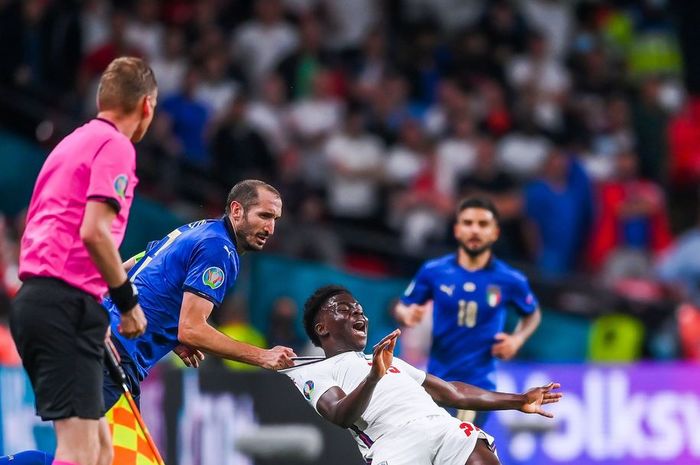 Bek timnas Italia, Giorgio Chiellini, melanggar winger timnas Inggris, Bukayo Saka, dalam laga final EURO 2020 di Stadion Wembley, Minggu (11/7/2021).