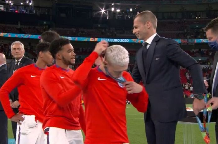Para pemain Inggris ramai-ramai langsung melepas medali runner-up Euro 2020 yang baru dikalungkan Presiden UEFA Aleksander Ceferin di Stadion Wembley, London, Minggu malam waktu setempat atau Senin (12/7/2021) dini hari WIB.