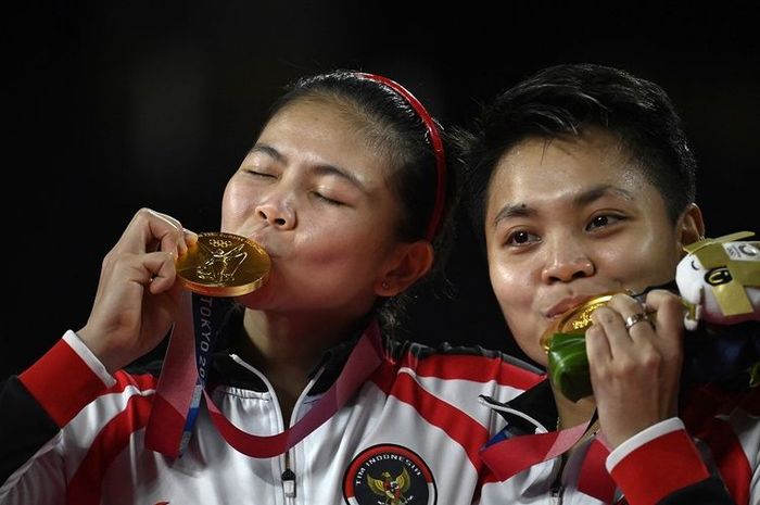 Pasangan ganda putri Indonesia Greysia Polii dan Apriyani Rahayu (kanan) berpose dengan medali emas bulu tangkis ganda putri pada upacara Olimpiade Tokyo 2020 di Musashino Forest Sports Plaza di Tokyo pada 2 Agustus 2021.