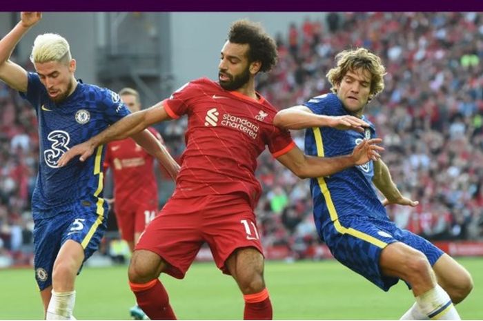 Penyerang Liverpool, Mohamed Salah (tengah), di antara dua pemain Chelsea, Jorginho (kiri) dan Marcos Alonso saat kedua tim bertemu di Anfield, Sabtu (28/8/2021) pada pekan ketiga Liga Inggris.