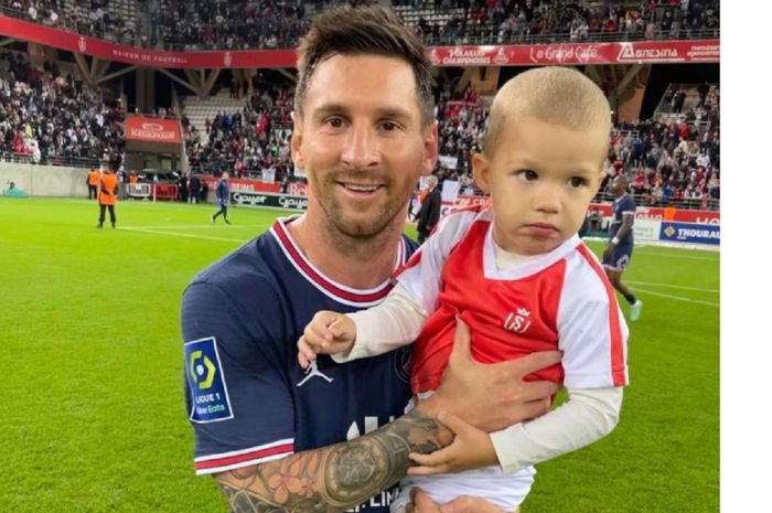 Lionel Messi menggendong bayi kiper Reims Predrag Rajkovic seusai debut untuk Paris Saint-Germain dalam Liga Prancis di Stade Auguste-Delaune II, Reims, Minggu (29/8/2021) malam watu setempat atau Senin dini hari WIB.