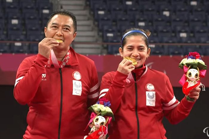Pasangan ganda campuran Indonesia, Hary Susanto/Leani Ratri Oktila, berpose dengan medali emas kelas SL3-SU5 di Yoyogi National Stadium, Tokyo, Jepang, Minggu (5/9/2021).