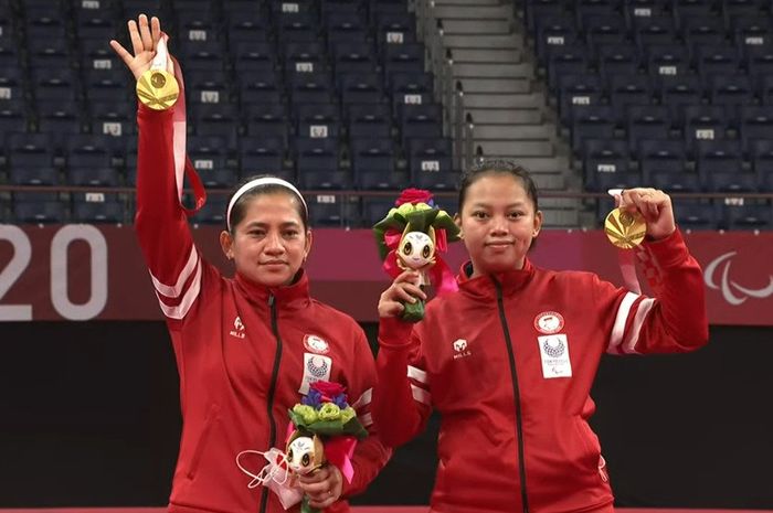 Pasangan ganda putri Indonesia, Leani Ratri Oktila/Khalimatus Sadiyah, berpose dengan medali emas kelas SL3-SU5 di Yoyogi National Stadium, Tokyo, Jepang, Sabtu (4/9/2021).