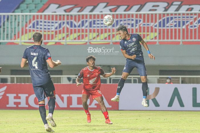 Pemain Arema FC, Rizky Dwi Febrianto (kanan), sedang menyundul bola dan dijaga ketat pilar PSM Makassar, Ilham Udin Armaiyn (tengah), dalam laga pekan pertama Liga 1 2021 di Stadion Pakansari, Bogor, Jawa Barat, 5 September 2021.