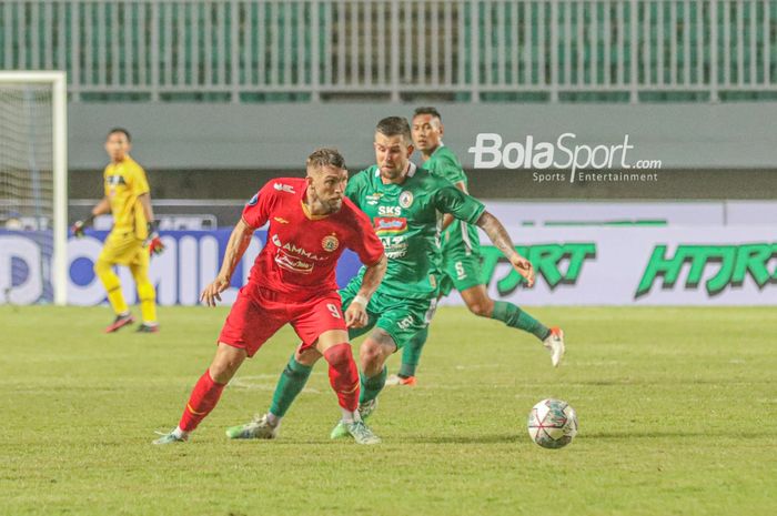 Striker Persija Jakarta, Marko Simic (kiri), sedang menguasai bola dan dijaga ketat oleh pemain PSS Sleman, Aaron Evans, dalam laga pekan pertama Liga 1 2021 di Stadion Pakansari, Bogor, Jawa Barat, 5 September 2021.