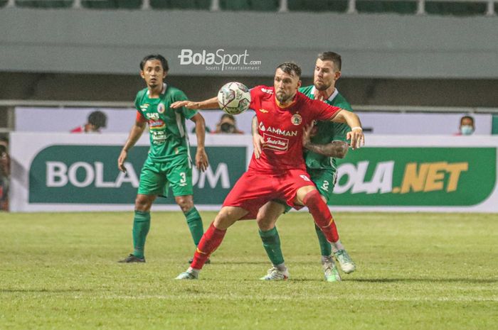 Penyerang Persija Jakarta, Marko Simic (kiri), sedang menjaga bolanya dari jangkauan pilar PSS Sleman, Aaron Evans (kanan), dalam laga pekan pertama Liga 1 2021 di Stadion Pakansari, Bogor, Jawa Barat, 5 September 2021.