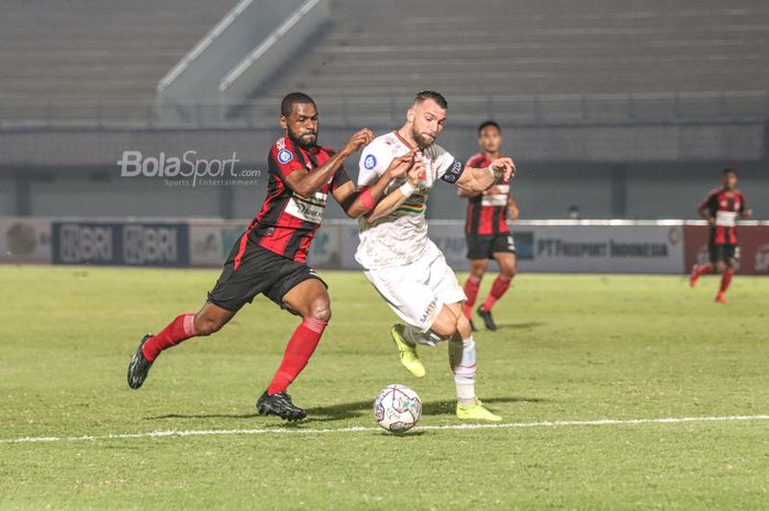 Bek Persipura Jayapura, Donnu Harold Monim (kiri), sedang berduel dengan striker Persija, Marko Simic (kanan), dalam laga pekan ketiga Liga 1 2021 di Stadion Indomilk Arena, Tangerang, Banten, 19 September 2021.