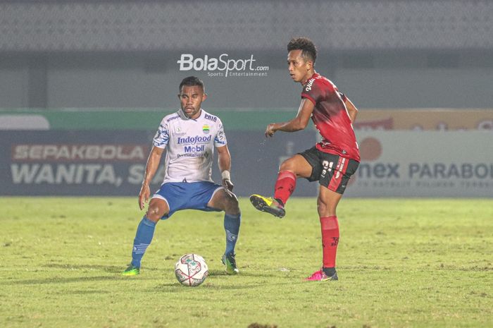 Pemain sayap kiri Bali United, Muhammad Rahmat (kanan), sedang mengoper bola dan dibayangi oleh bek Persib Bandung, Ardi Idrus (kiri), dalam laga pekan ketiga Liga 1 2021 di Stadion Indomilk Arena, Tangerang, Banten, 18 September 2021.