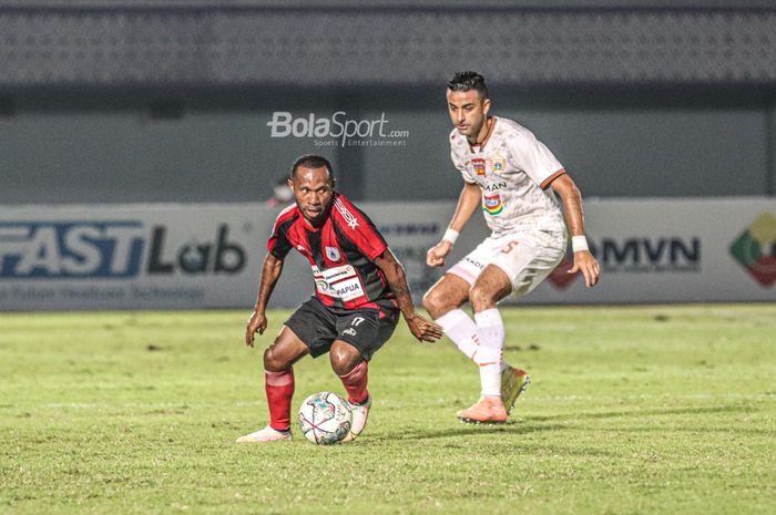 Pemain Persipura Jayapura, Yohanes Pahabol (kiri), sedang menguasai bola dan dibayangi bek Persija Jakarta, Otavio Dutra (kanan), dalam laga pekan ketiga Liga 1 2021 di Stadion Indomilk Arena, Tangerang, Banten, 19 September 2021.