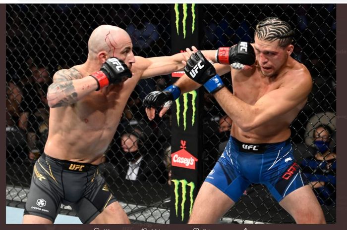Rekan seperguruan Israel Adesanya, Alexander Volkanovski saat melepaskan pukulan yang mengenai Brian Ortega ketika bertarung pada UFC 266 (26/9/2021).