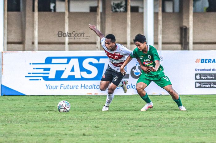 Bek sayap kanan Madura United,Dodi Alekvan Djin (kiri), sedang menguasai bola dan dibayangi oleh pemain PSS Sleman, Hokky Caraka (kanan), dalam laga pekan keempat Liga 1 2021 di Stadion Madya, Senayan, Jakarta, 2 Oktober 2021.