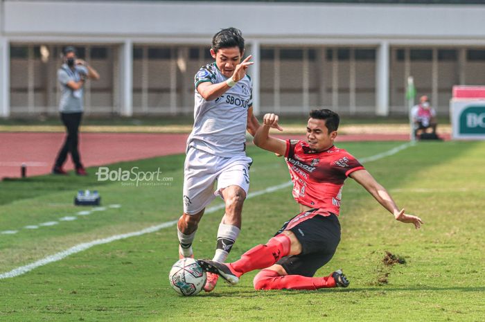 Bek Bali United, Ricky Fajrin (kanan), sedang menekel pergerakan bola yang dikuasai oleh pemain Tira Persikabo, Firza Andika (kiri), Striker Tira Persikabo, Dimas Drajad, melakukan selebrasi seusai mencetak gol dalam pekan keenam Liga 1 2021 di Stadion Madya, Senayan, Jakarta, 2 Oktober 2021.