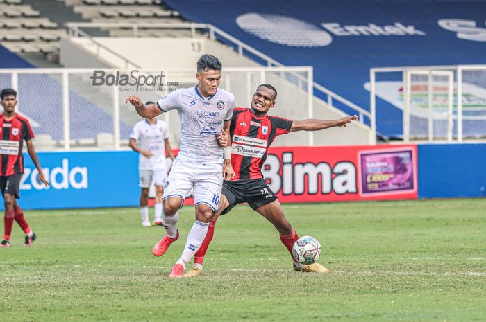 Bek Persipura Jayapura, Israel Wamiau (kanan), sedang menjaga bolanya dari rebutan penyerang Arema FC, Muhammad Rafli (kiri), dalam laga pekan kelima Liga 1 2021 di Stadion Madya, Senayan, Jakarta, 29 September 2021.